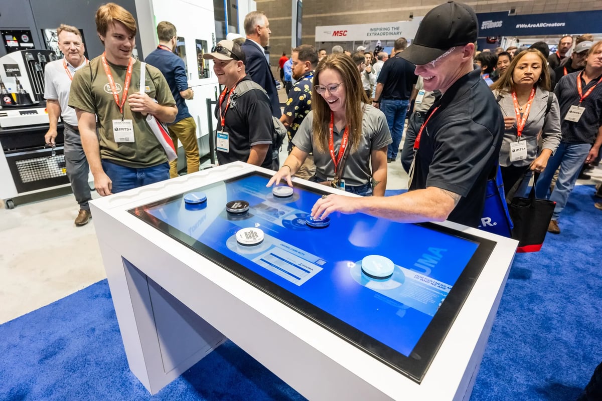 Attendees using an interactive touch table at a trade show